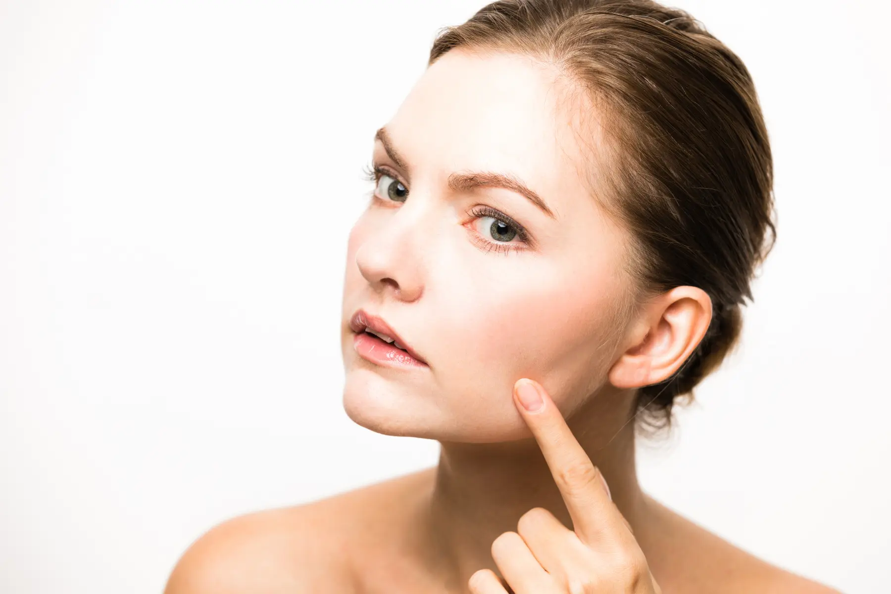 Close‑up of a woman touching her jawline, illustrating facial skin tightening