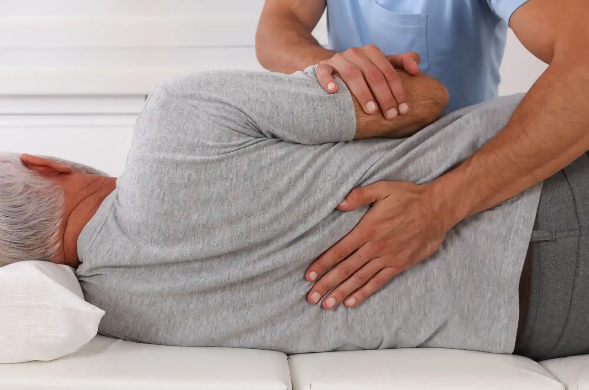 “Chiropractor examining a patient’s back with hands on the spine, illustrating chiropractic care treatment.”