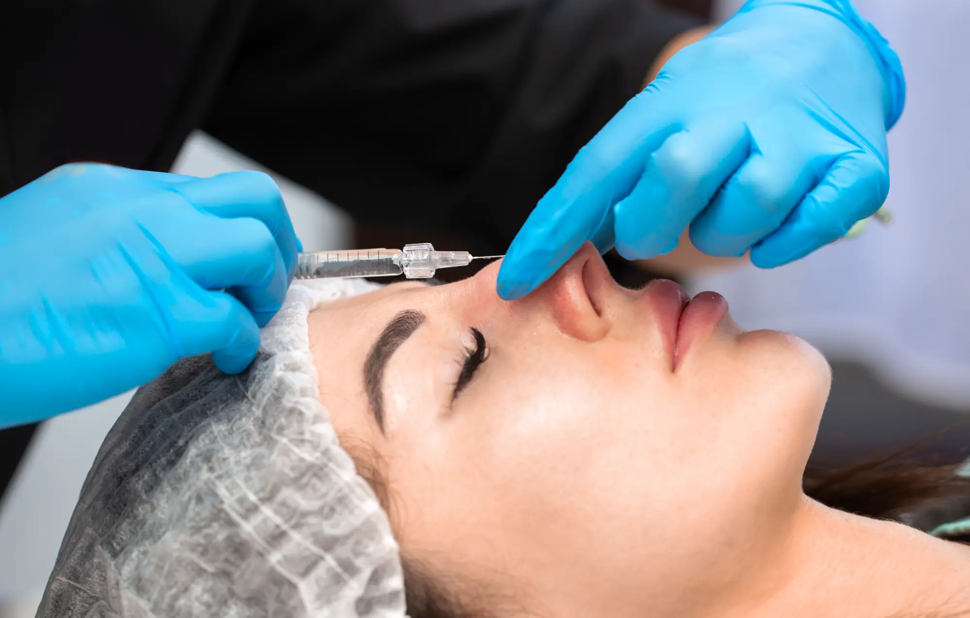 “Close‑up of a person’s face focusing on the nose, illustrating a liquid rhinoplasty procedure.”